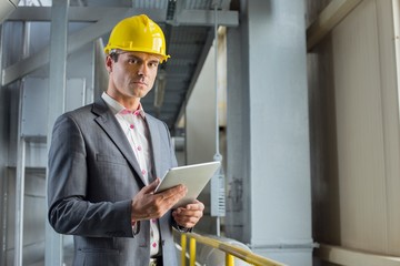 Portrait of confident male architect holding digital tablet in industry