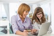© MDBPIXS - Cheerful mother and daughter shopping online at home during Christmas