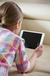 © MDBPIXS - Rear view of girl using tablet PC at home