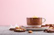 © zgurski1980 - Cup of hot chocolate and pieces of milk chocolate with almonds on a gray and pink background. Side view, selective focus.