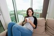 © MDBPIXS - Beautiful woman having coffee on sofa at home