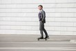 © MDBPIXS - Businessman skateboarding on street
