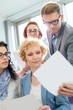 © MDBPIXS - Businessman showing photograph to colleagues in creative focus