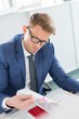 © MDBPIXS - Businessman reading file at desk in creative office