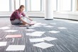 © MDBPIXS - Businessman analyzing photographs while sitting on floor at creative office
