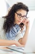 © MDBPIXS - Businesswoman using laptop at desk in creative office