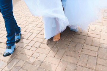 Wall Mural - barefooted bride and groom in blue shoes