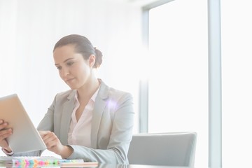 Wall Mural - Young businesswoman using digital tablet in office