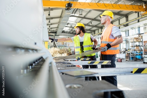 Cuadros en Lienzo Male manual workers manufacturing sheet metal at industry