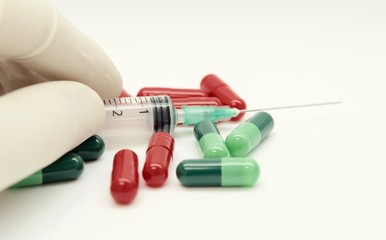 Wall Mural - Green capsules red capsules and a syringe isolated