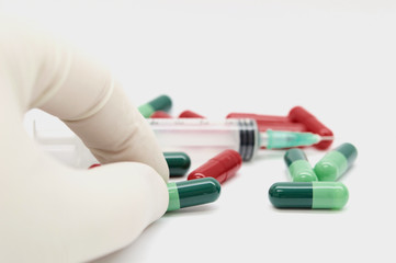 Wall Mural - Green capsules red capsules and a syringe isolated