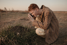 Young Man Taking Picture Of Dirt Pile