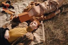 Young Travelers Resting On Grass In Field