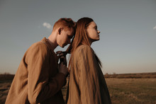 Brother And Sister Standing In Field In Evening