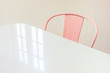 © Darren Seamark/Stocksy - Pink chair and a white table