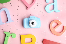 Toy Camera And Colorful Wooden Letters On Pink Background, Flat Lay. Future Photographer