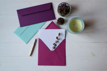 Wall Mural - The pink envelope with note blank on the white wooden table. Beautiful desktop. Background with place for text.