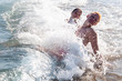© nedomacki - Mother and daughter jumping and playing in the ocean in the big waves. Play with the waves on the beach