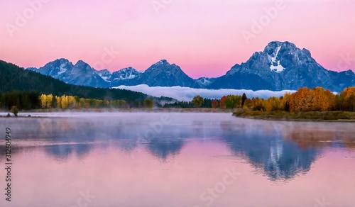 Fotomural The beautiful pink alpenglow over the dramatic Teton mountain range at sunrise on an autumn morning