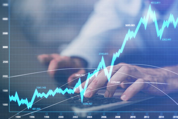 Forex graph with businessman working on computer in office on background. Concept of hardworking. Multi exposure.