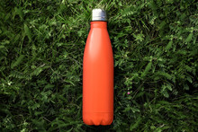 Top View Of Reusable Steel Thermo Water Bottle With Mockup On Green Grass, Lush Lava Color.