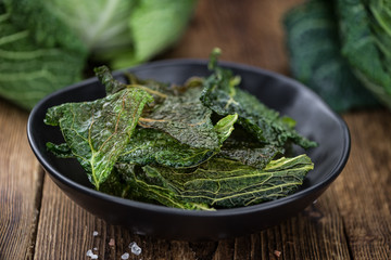 Some fresh Savoy Chips on wooden background (selective focus; close-up shot)