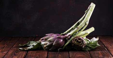 Wall Mural - artichokes on rustic background. fresh raw organic artichoke flower.