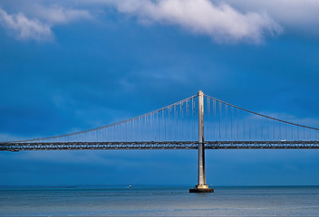 Fototapete - Sunlight on Bay Bridge Through Storm Clouds