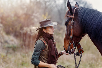 Portrait of woman and horse outdoors. Woman stroking a horse.