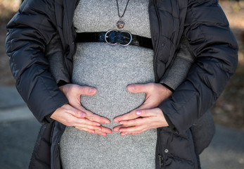 Pregnant woman she and her husband touch belly