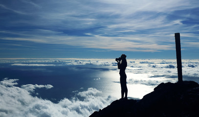 Young girl trekking and taking photos on Pico volcano (2351m) on Pico Island, Azores, Portugal, Europe