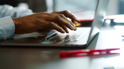 Close up hands man african american young uses laptop typing touch work in office programmer sunlight business sucess slow motion