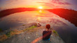 © raisondtre - Beautiful woman sits in a pose of a half lotus on high place amazing view of the lake sunset summer sky, practice yoga meditation. Kundalini energy. Solitude harmony, mental freedom zen mind concept.