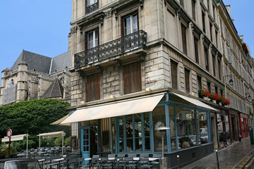 Canvas Print - Paris, street with apartment buildings with shops and cafes on the ground floor