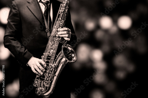 Fototapeta saksofon  gram-na-saksofonie-na-czarnym-tle-jazzy-sepia