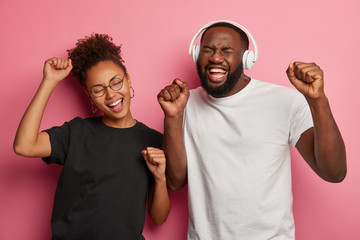 Sticker - Music makes us happy. Positive energized dark skinned woman and man dance to rhythm of song with pleased cheerful faces, dressed in black and white clothing. People, technology, fun, leisure