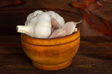 Garlic Heads In Wooden Bowl On Wooden Table, Close Up
