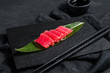 Fresh raw sashimi tuna on a stone Board. Black background. Top view