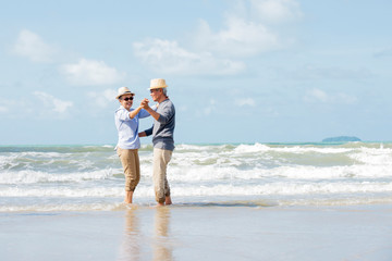 Happy asian couple dancing on the beach enjoy  life