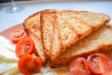 Simple breakfast, top view: fried eggs, toast, cheese, cherry tomatoes