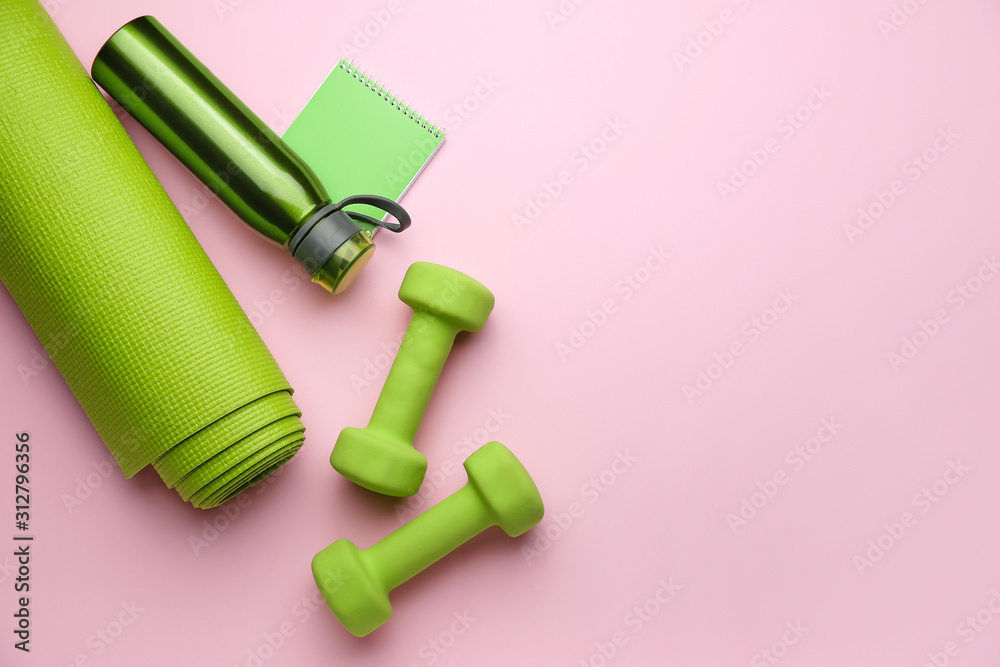 Dumbbells with notebook, yoga mat and bottle of water on color background - obrazy, fototapety, plakaty 