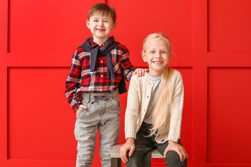 Poster - Cute little children in autumn clothes near color wall