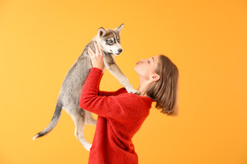 Canvas Print - Cute teenage girl with funny husky puppy on color background