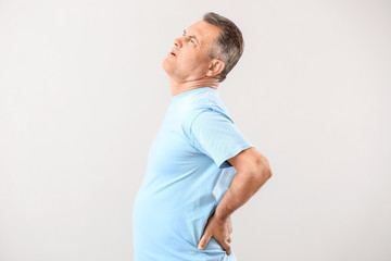 Poster - Mature man suffering from back pain on white background