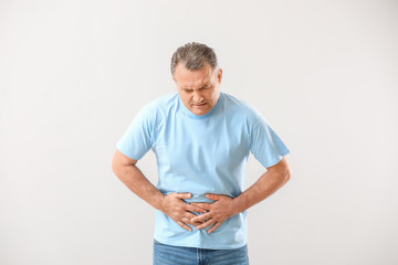 Poster - Mature man suffering from abdominal pain on white background