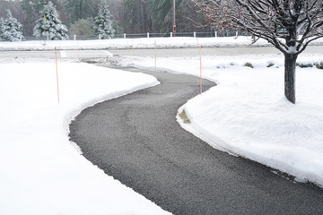 Poster - Winding pedestrian sidewalk with snow removed after winter snow