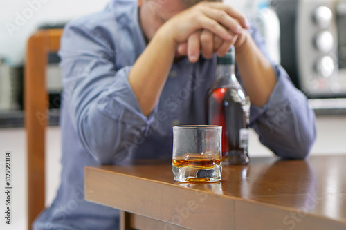 Fotografía A man with bottle of whiskey on the kitchen