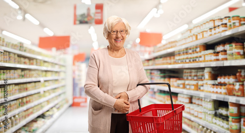 Senior female with a shopping basket in a supermarket