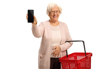 Poster - Senior female customer with a shopping basket and a mobile phone