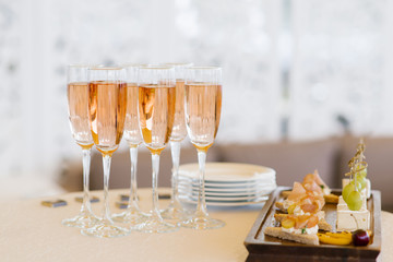 Glasses of pink champagne on the buffet table with snacks